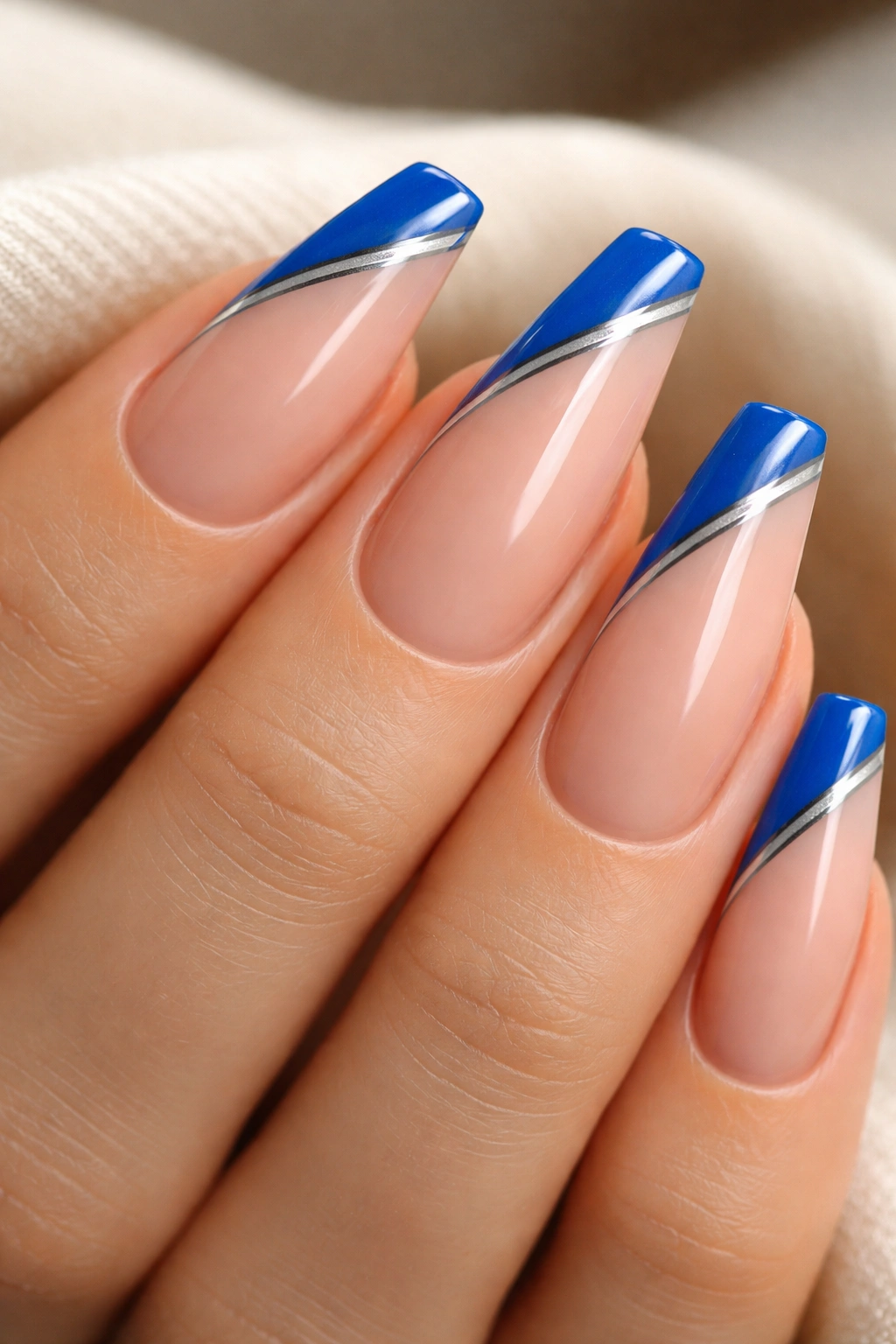Electric blue side-swipe nails with a silver stripe on a nude base.
