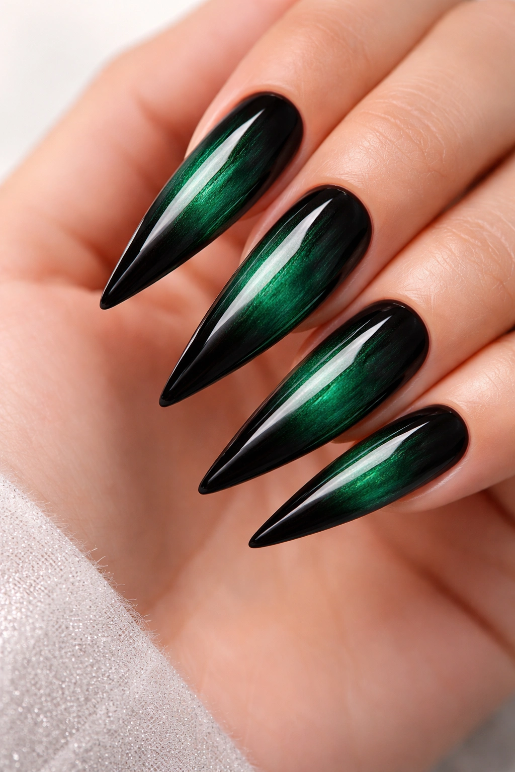Close-up emerald to black ombre stiletto nails