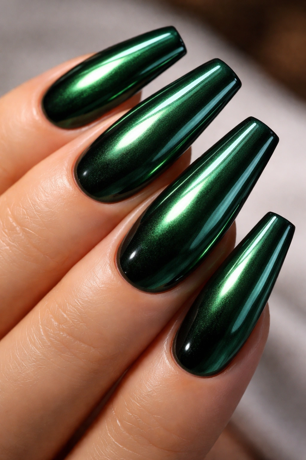 Close-up of emerald green chrome nails with mirror finish
