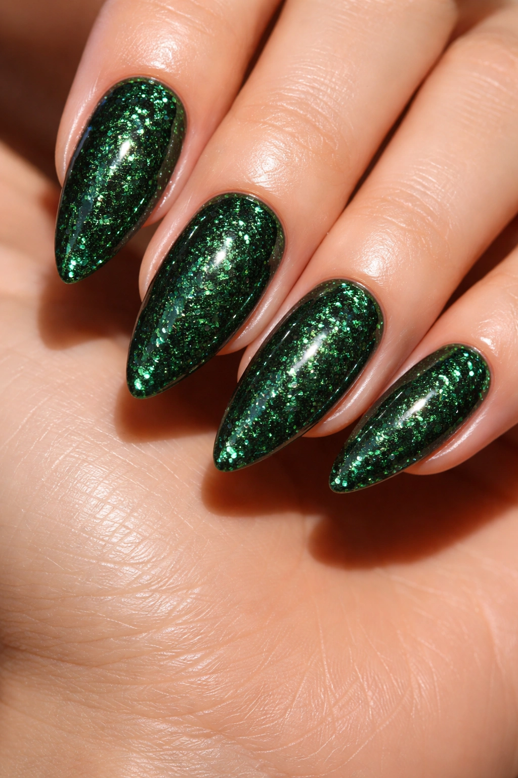 Deep emerald glitter nails on almond shape with high gloss