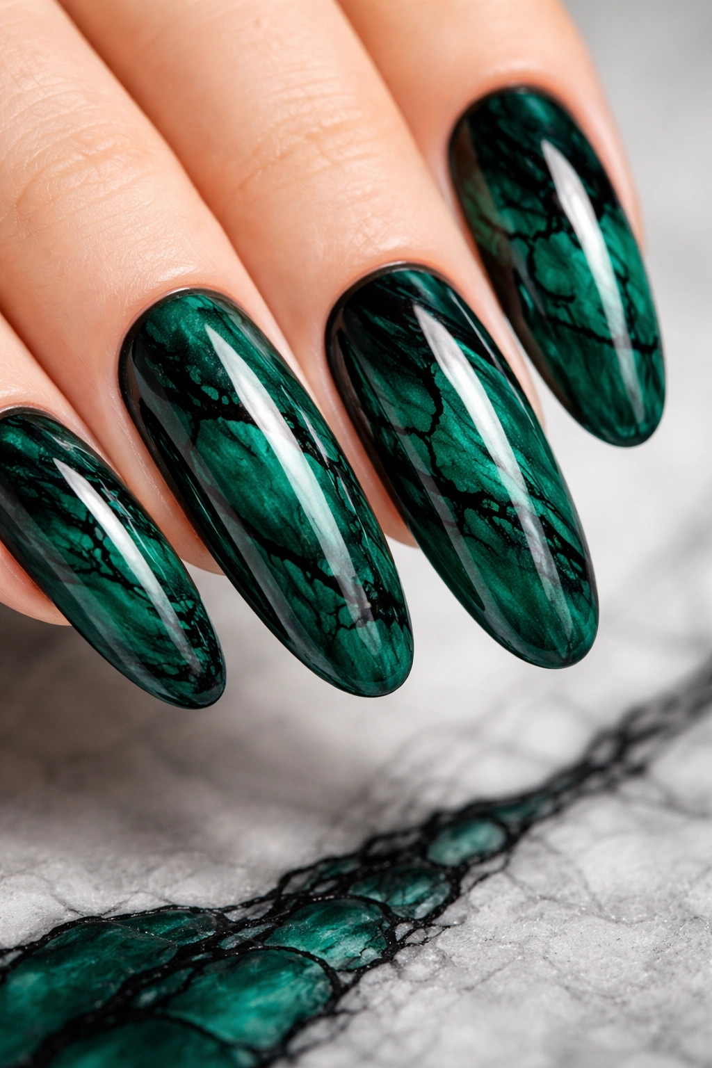 Close-up of emerald green marble nails with black veining on long round nails, ultra-detailed photorealistic