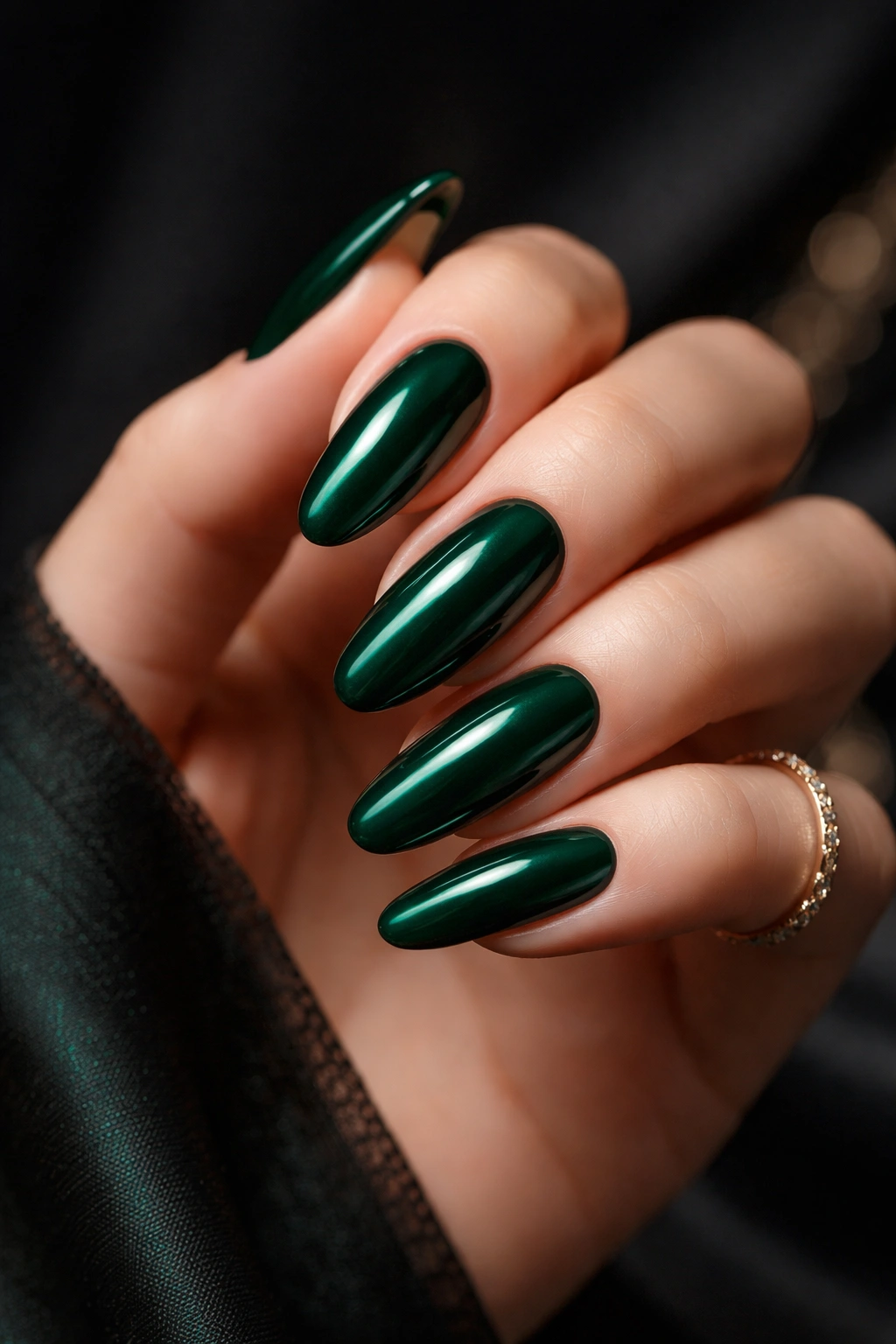 Close-up of deep emerald green long oval nails with glossy finish