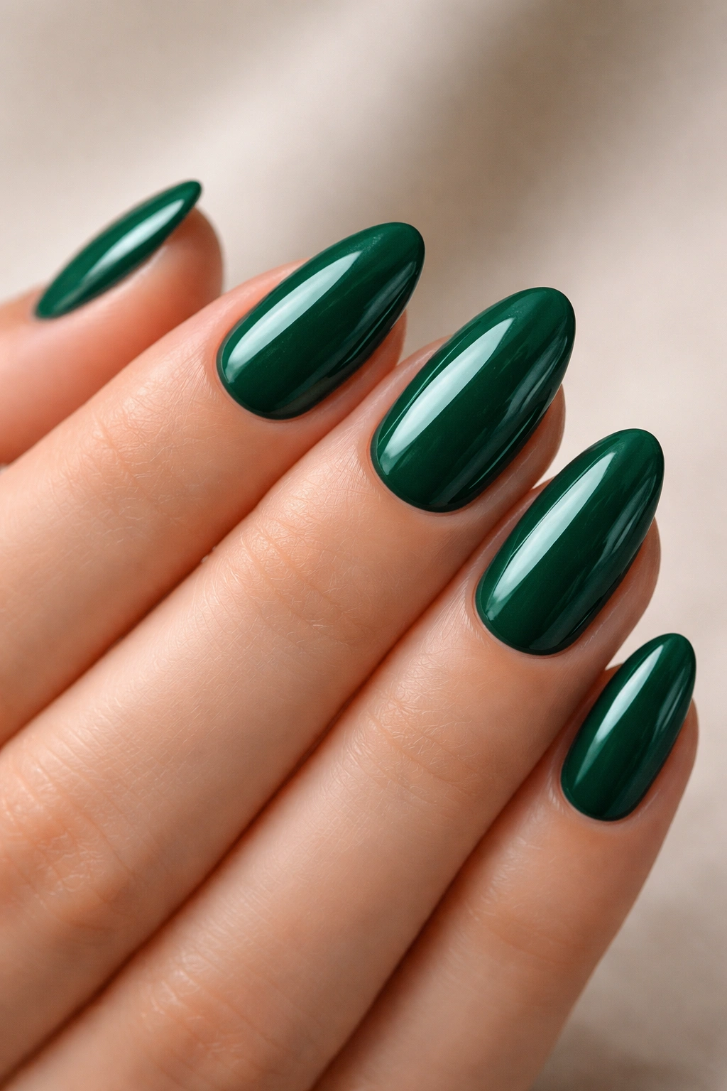 Close-up of emerald green short almond nails with clean minimal edges