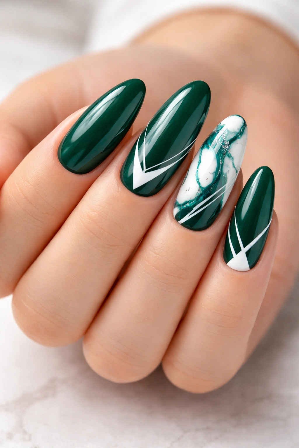 Emerald green nails with white marble and geometric accents on long ovals