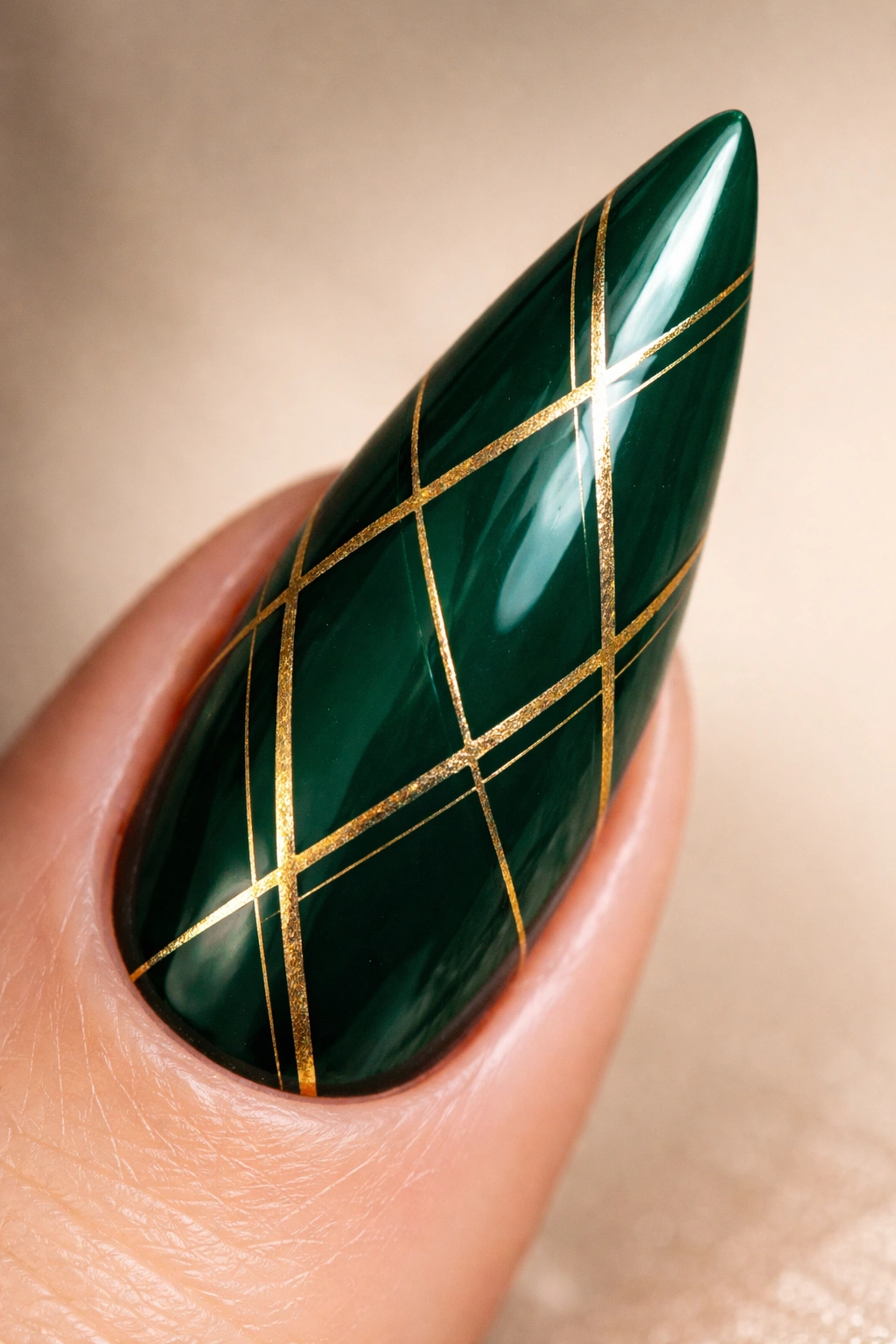 Stiletto nail emerald green with gold geometric patterns close-up