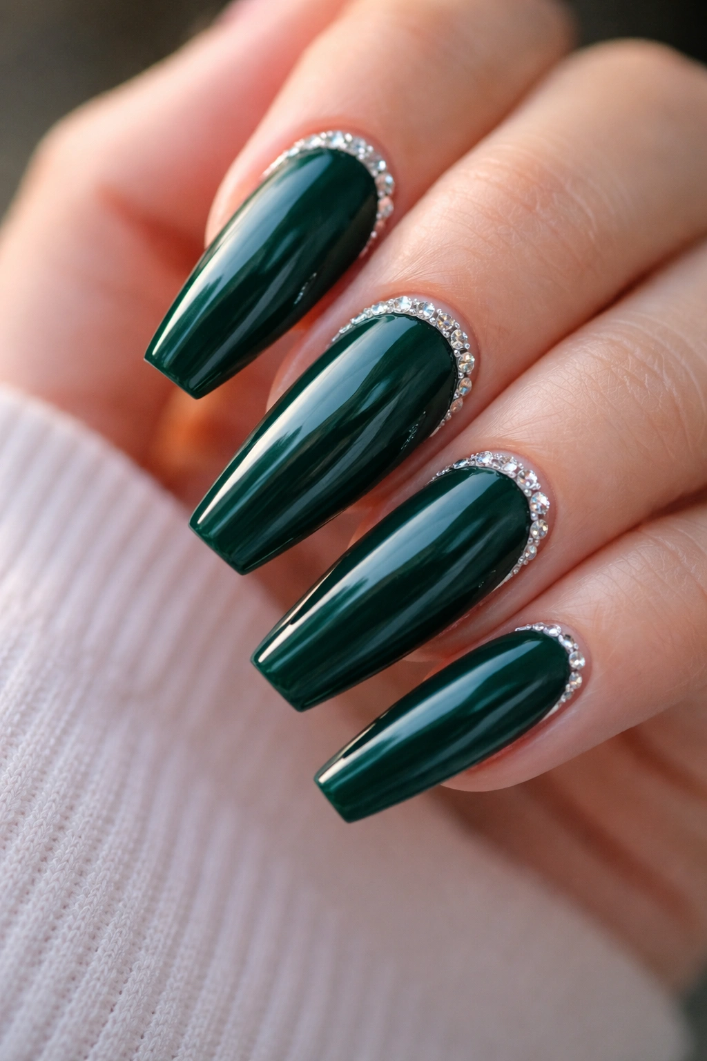 Deep emerald nails with a slim rhinestone cuticle frame