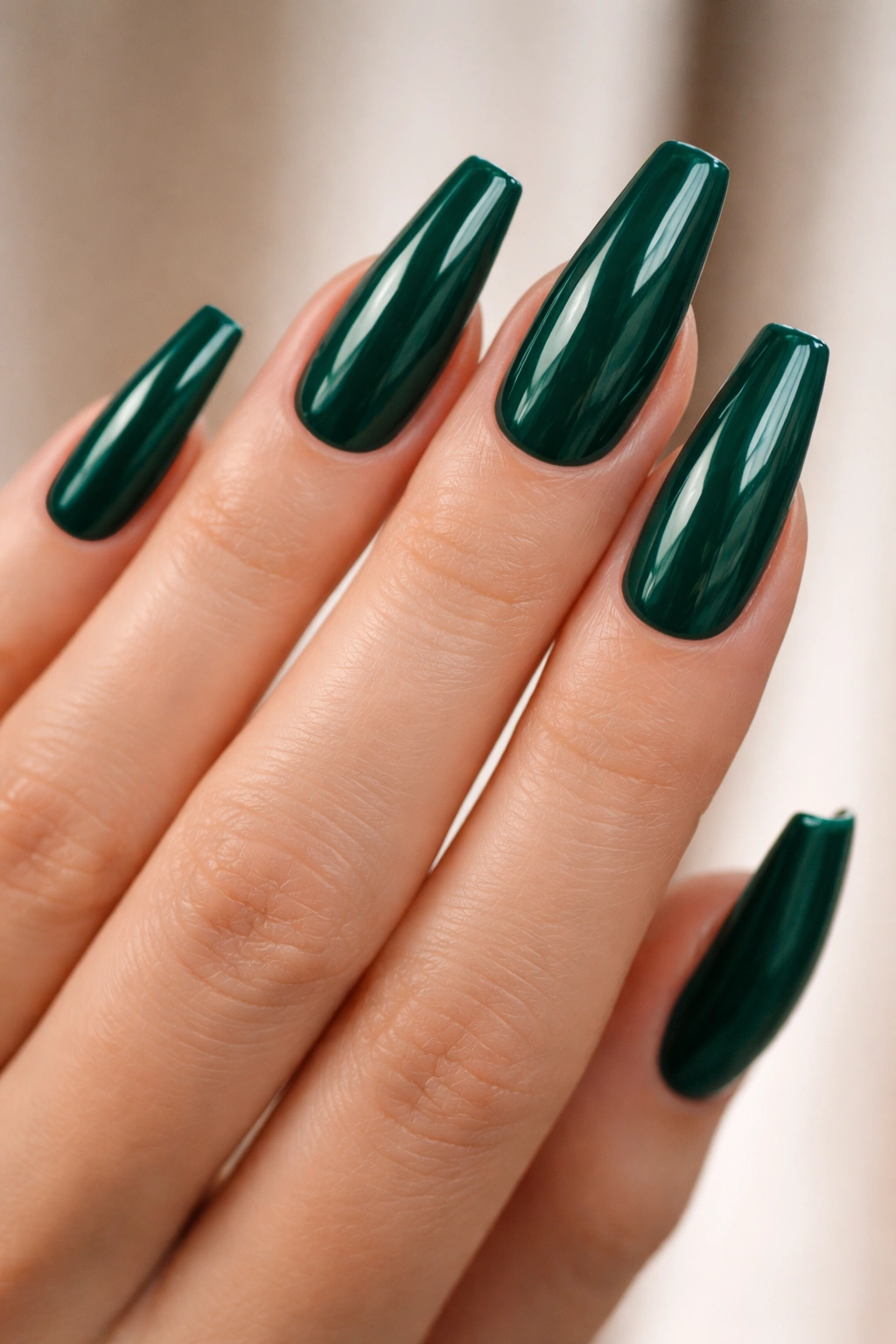Close-up of emerald ballerina nails on a bare hand with glossy finish