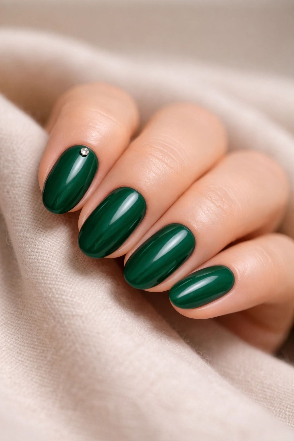 Short emerald nails with a single tiny gem near the cuticle