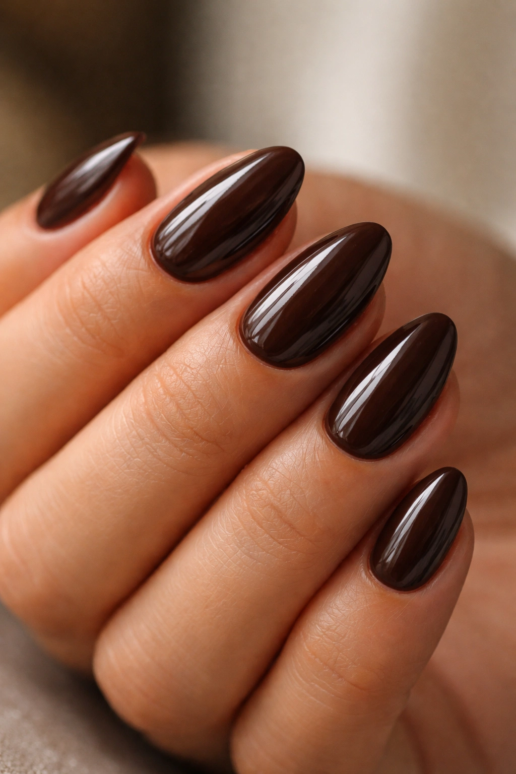 Close-up of espresso brown almond nails with glossy finish
