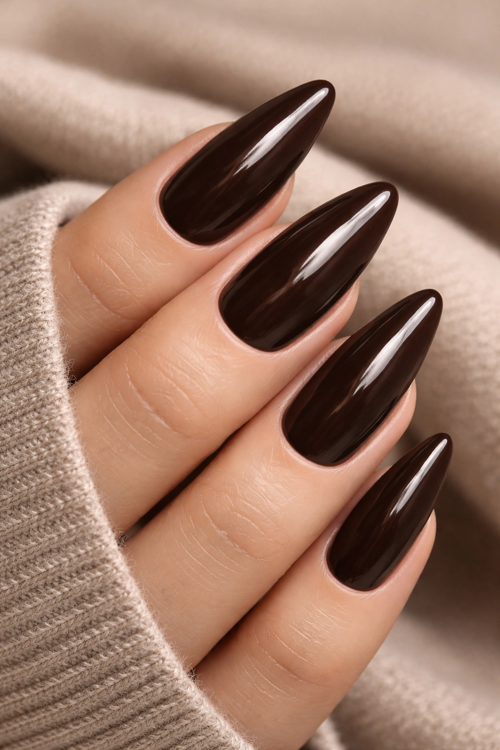 Close-up of nails painted in deep espresso brown with a glossy finish