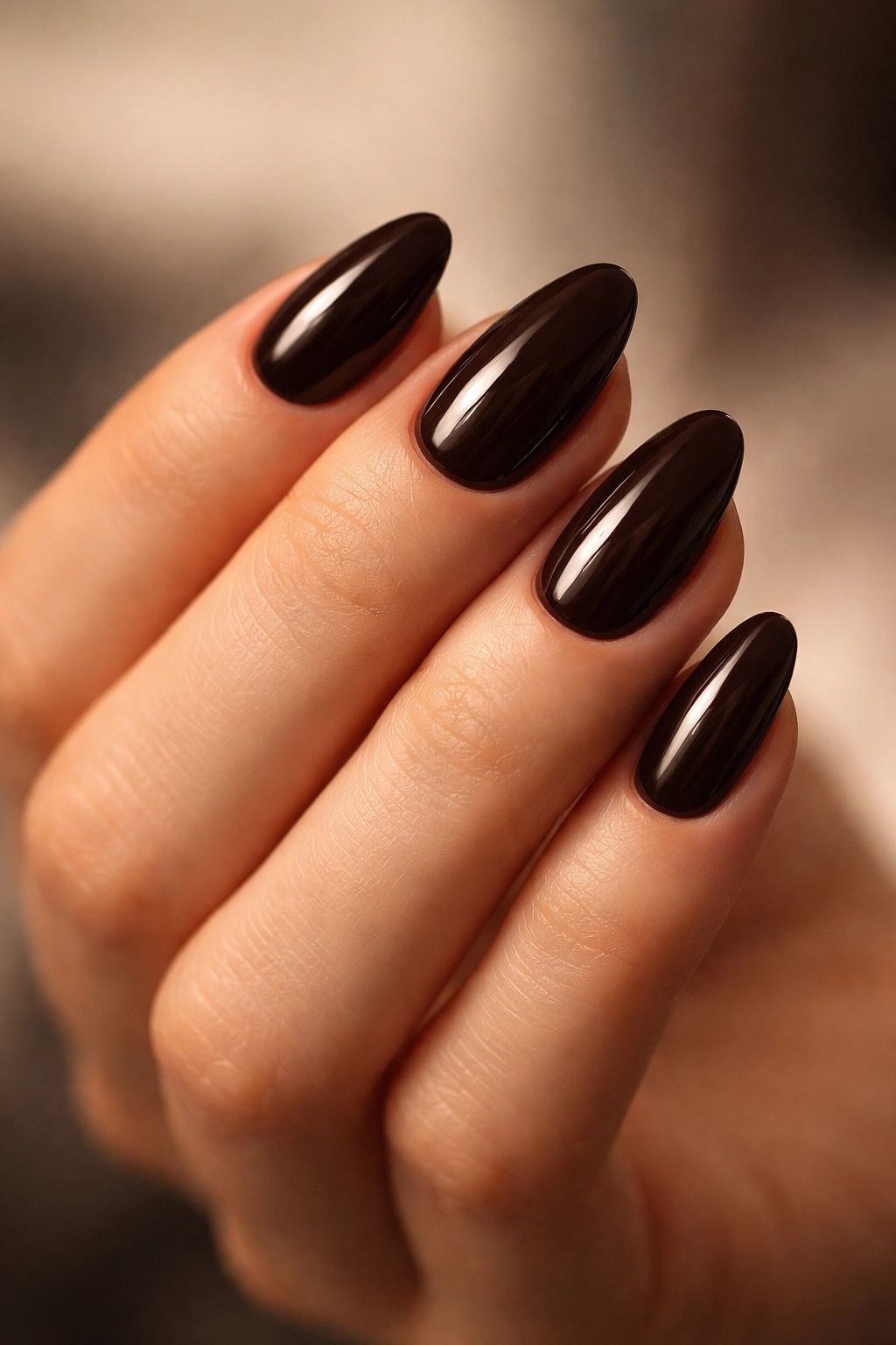 Close-up of espresso brown almond nails on a hand