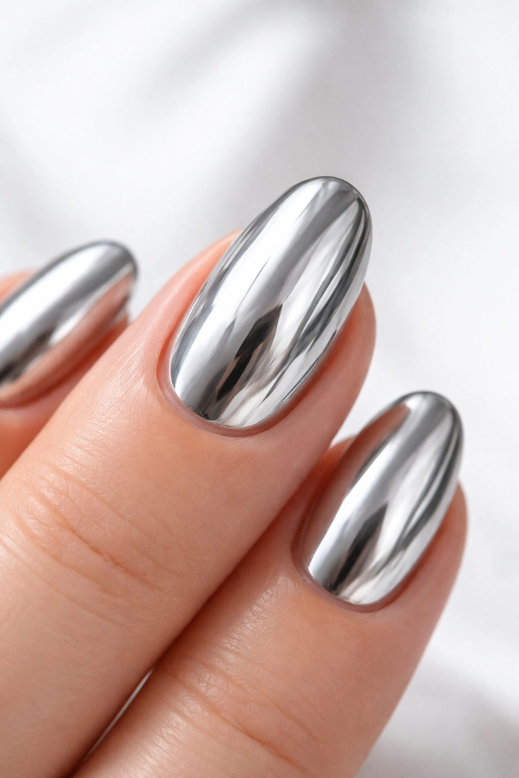 Mirror-like chrome nail reflecting light in final look