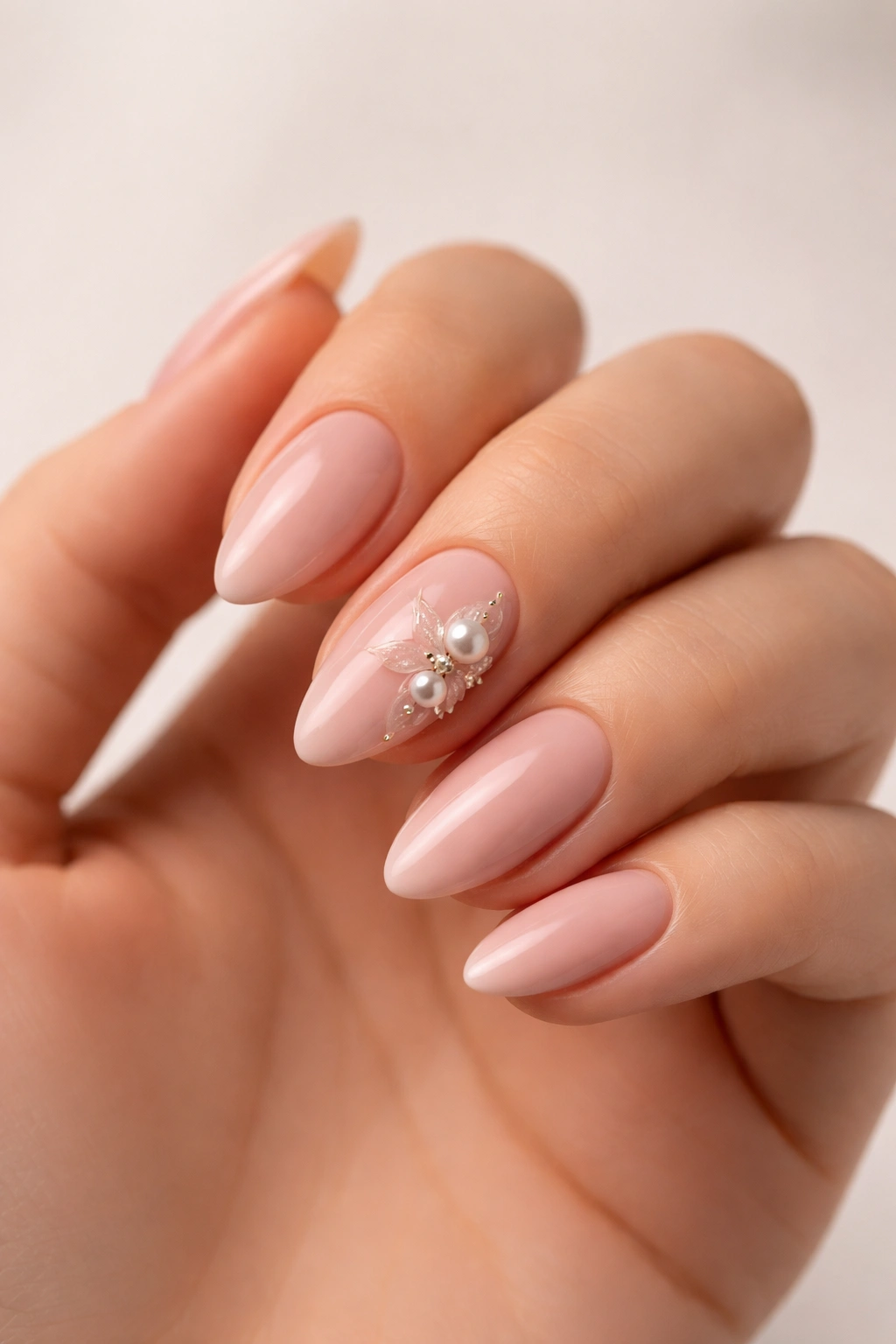 Close-up of a hand with a single refined 3D nail accent on the ring finger