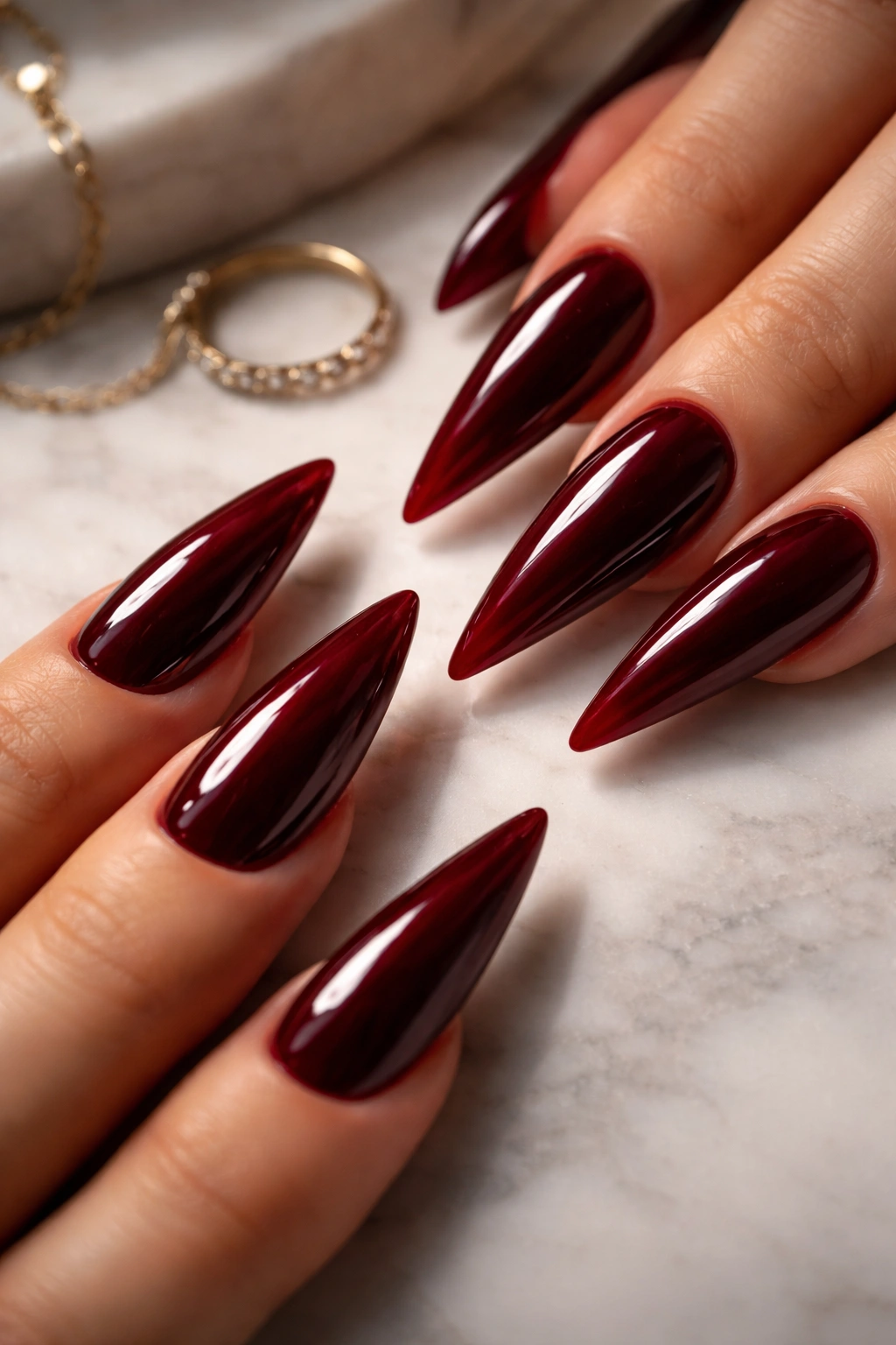 Nail arrangement of dark red stiletto nails on a clean surface