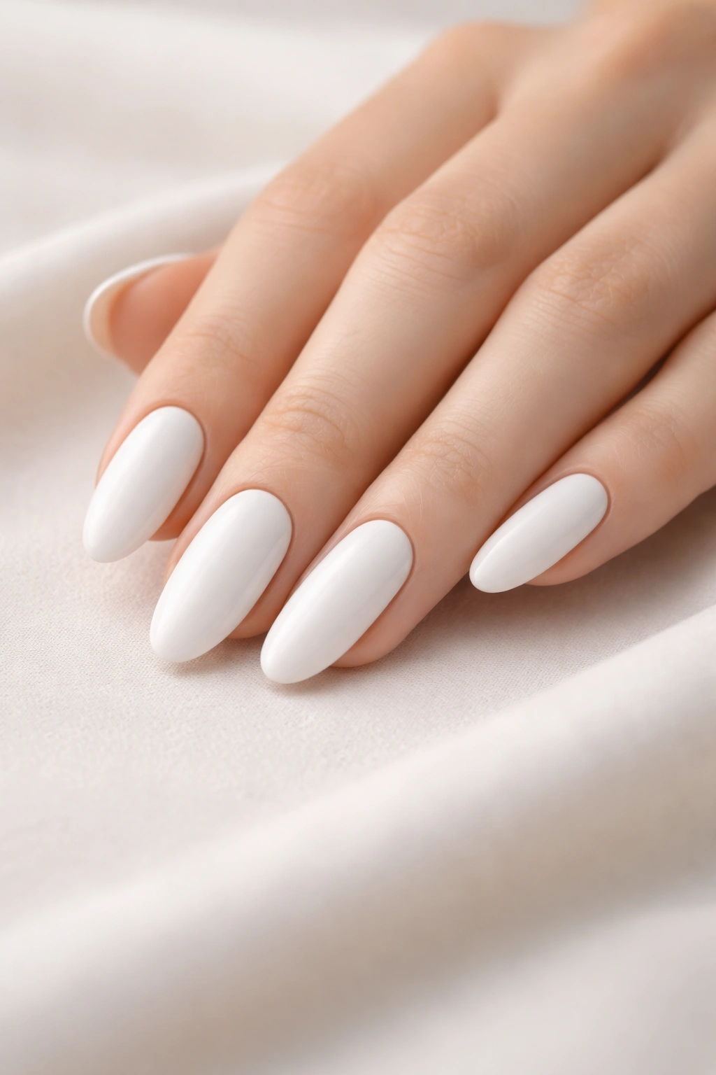 Close-up of white long oval nails with a clean finish