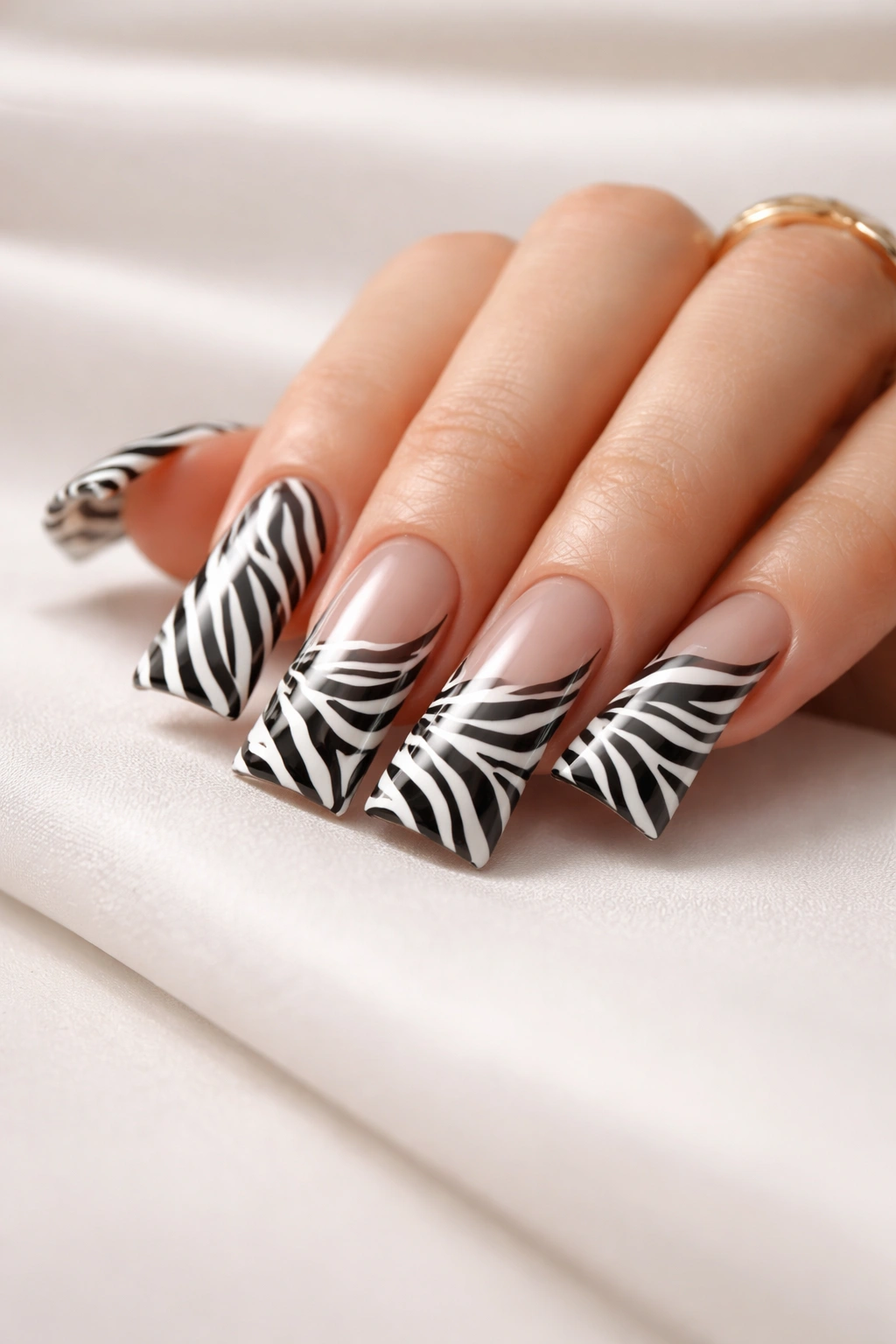 Close-up of duck nail design with zebra stripes on curved tips, polished and refined
