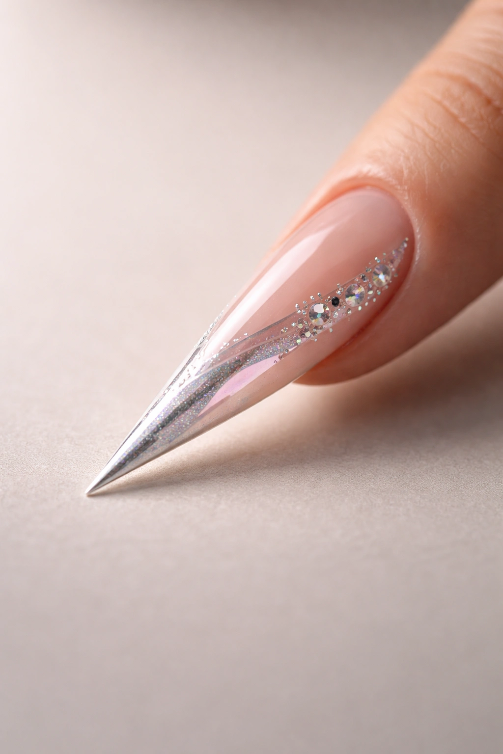 Minimalist close-up of a stiletto nail on a neutral surface