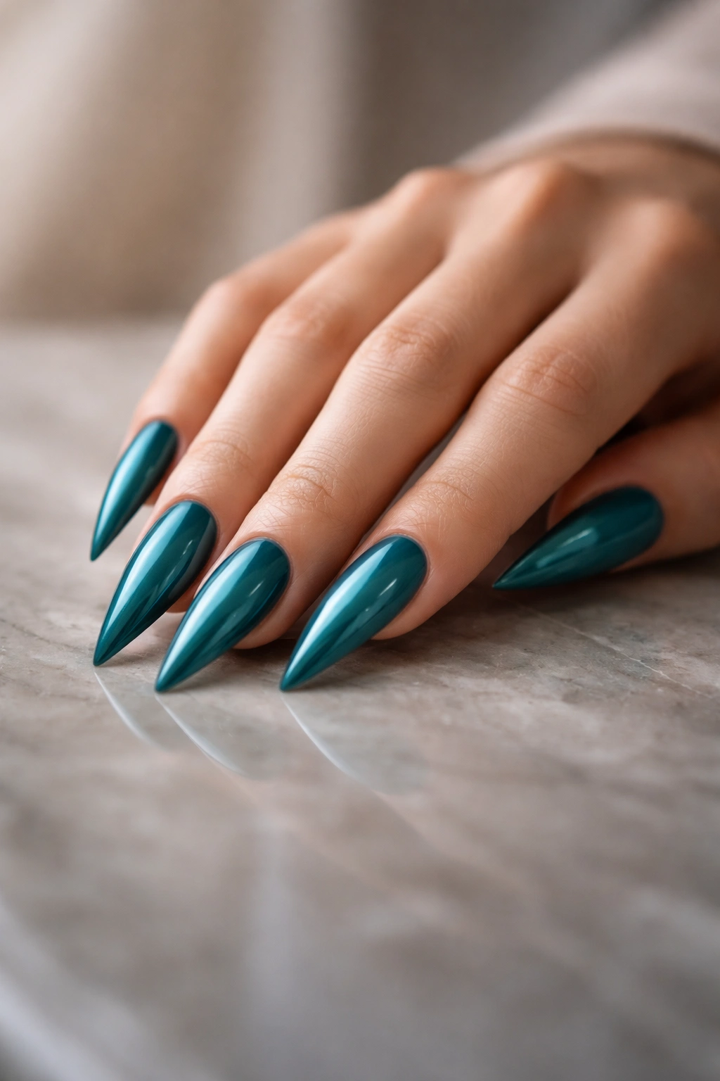 Contemplative hand with teal stiletto nails on a reflective surface