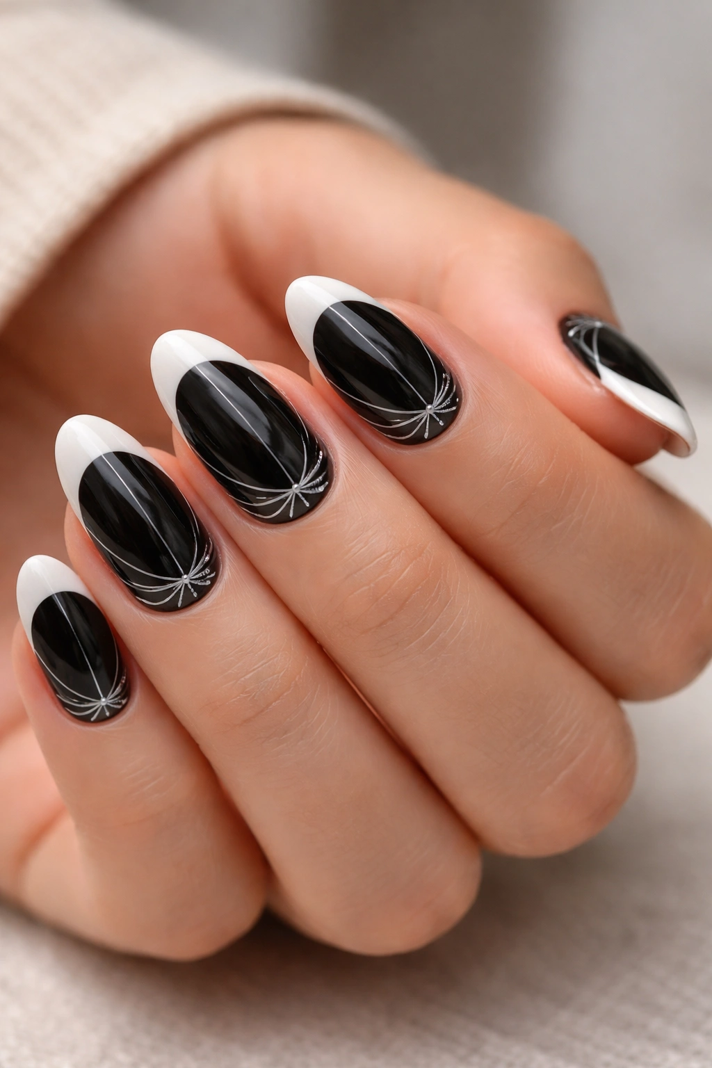 Black French nails with delicate fine-line nail art on short almond nails.
