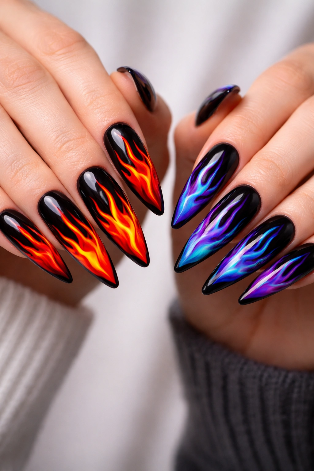 Long nails with red-orange flames on one hand and blue-purple flames on the other