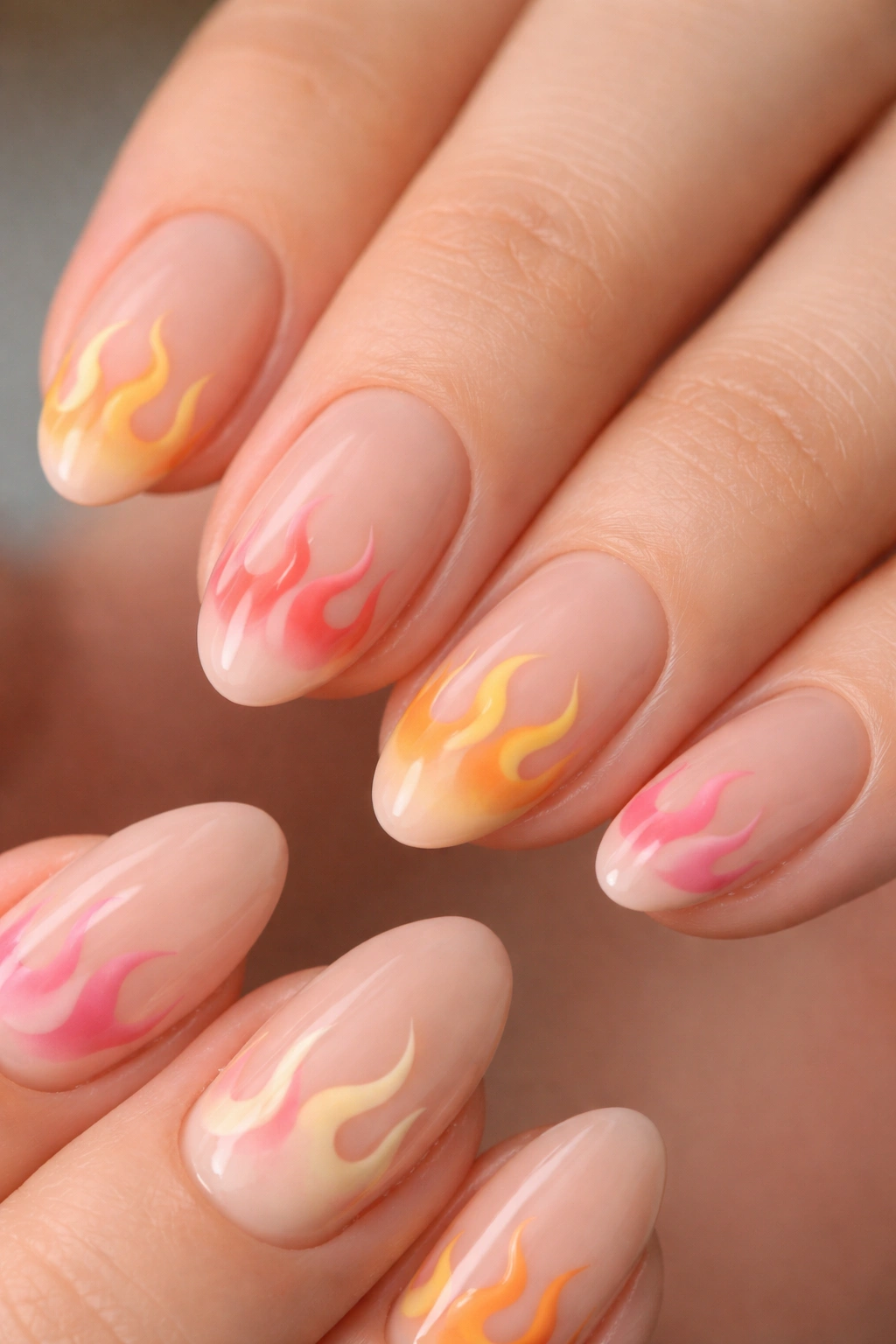 Close-up of short almond nails with small curved flame designs on nude base