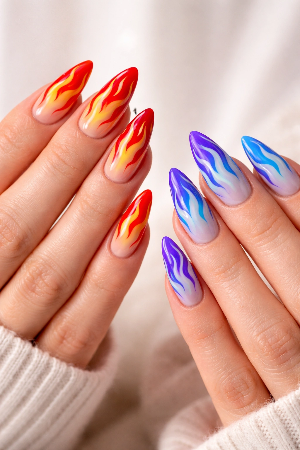 Two hands with flame nail art in contrasting warm and cool color schemes.