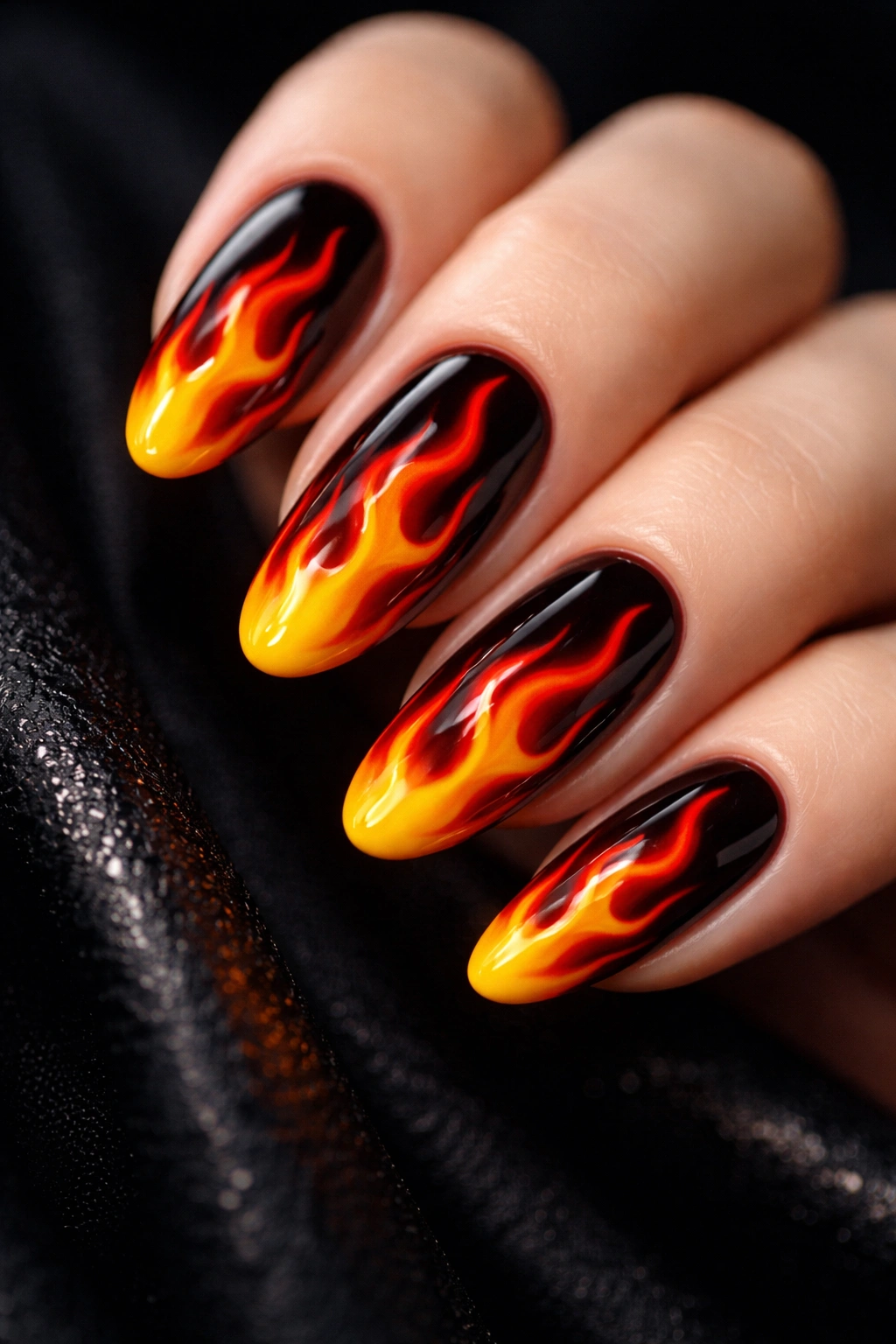 Close-up of nails with red orange yellow flame nail art on a dark base