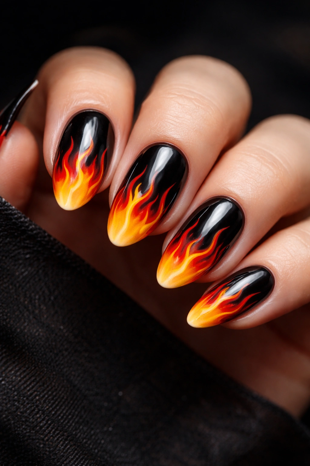 Close-up of flame tip nails with black base and colorful flames