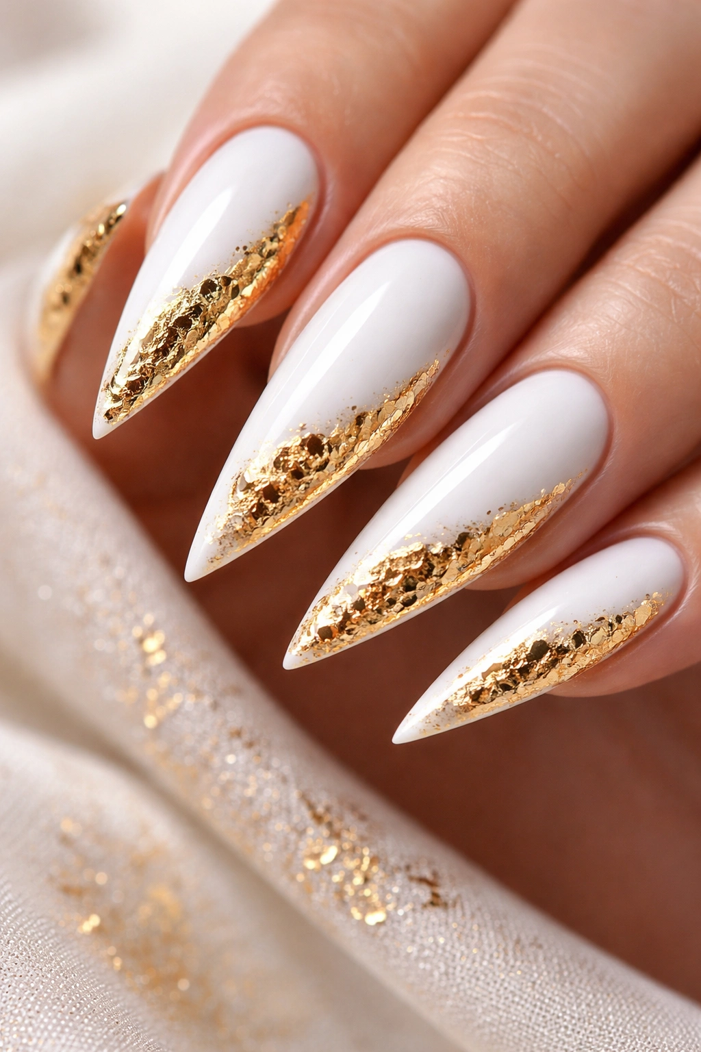 White stiletto nails with gold foil accents