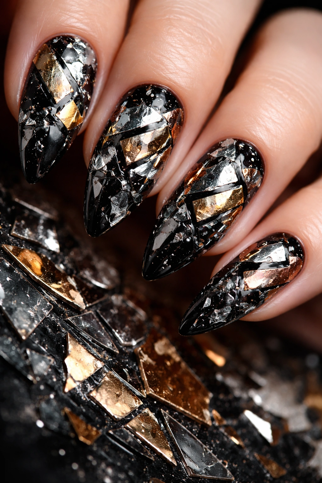 Close-up of shattered mirror nail art with multi-metal foil on a dark base.