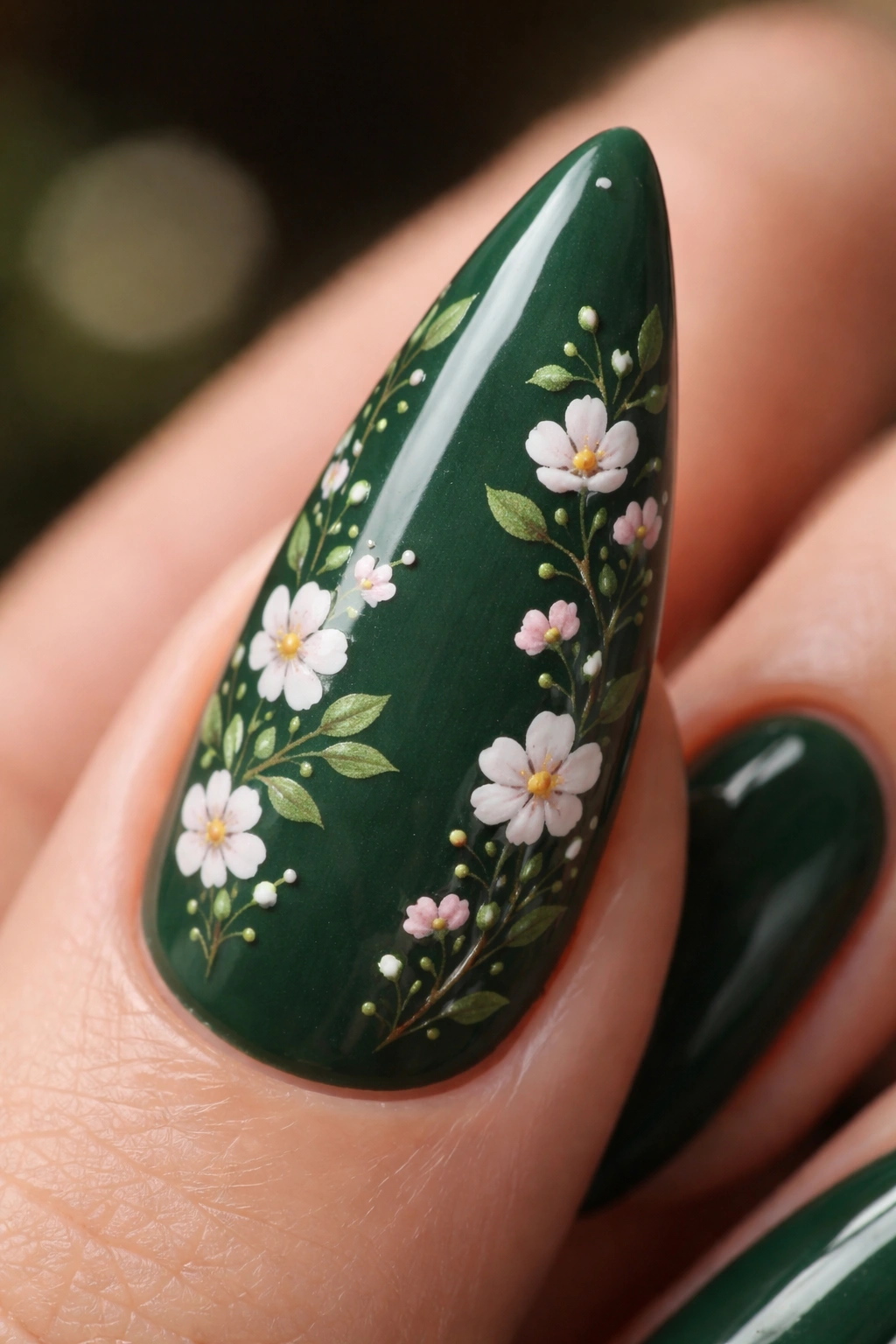 Nail with forest green base and tiny hand-painted florals macro shot
