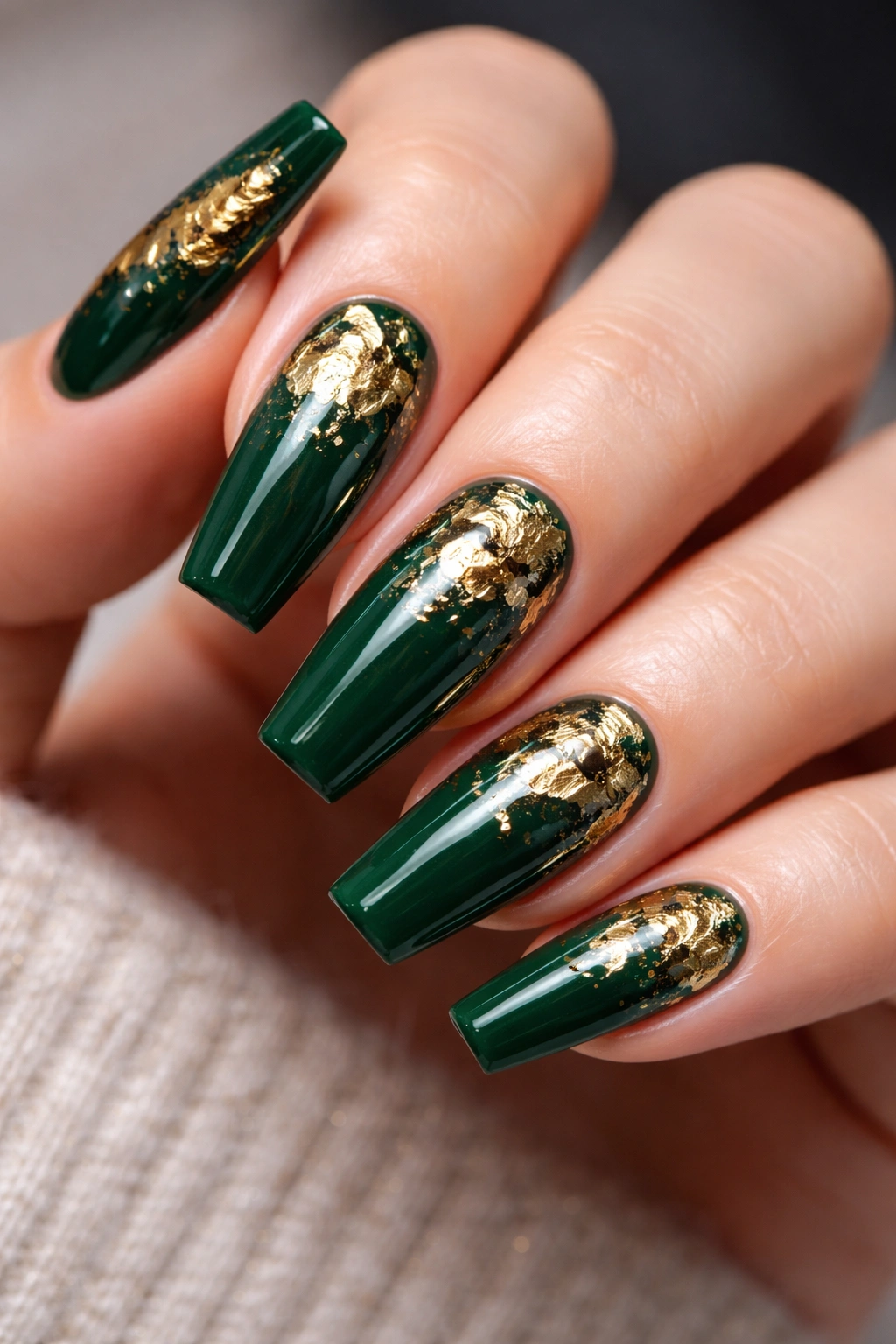Forest green nails with gold foil accents close-up