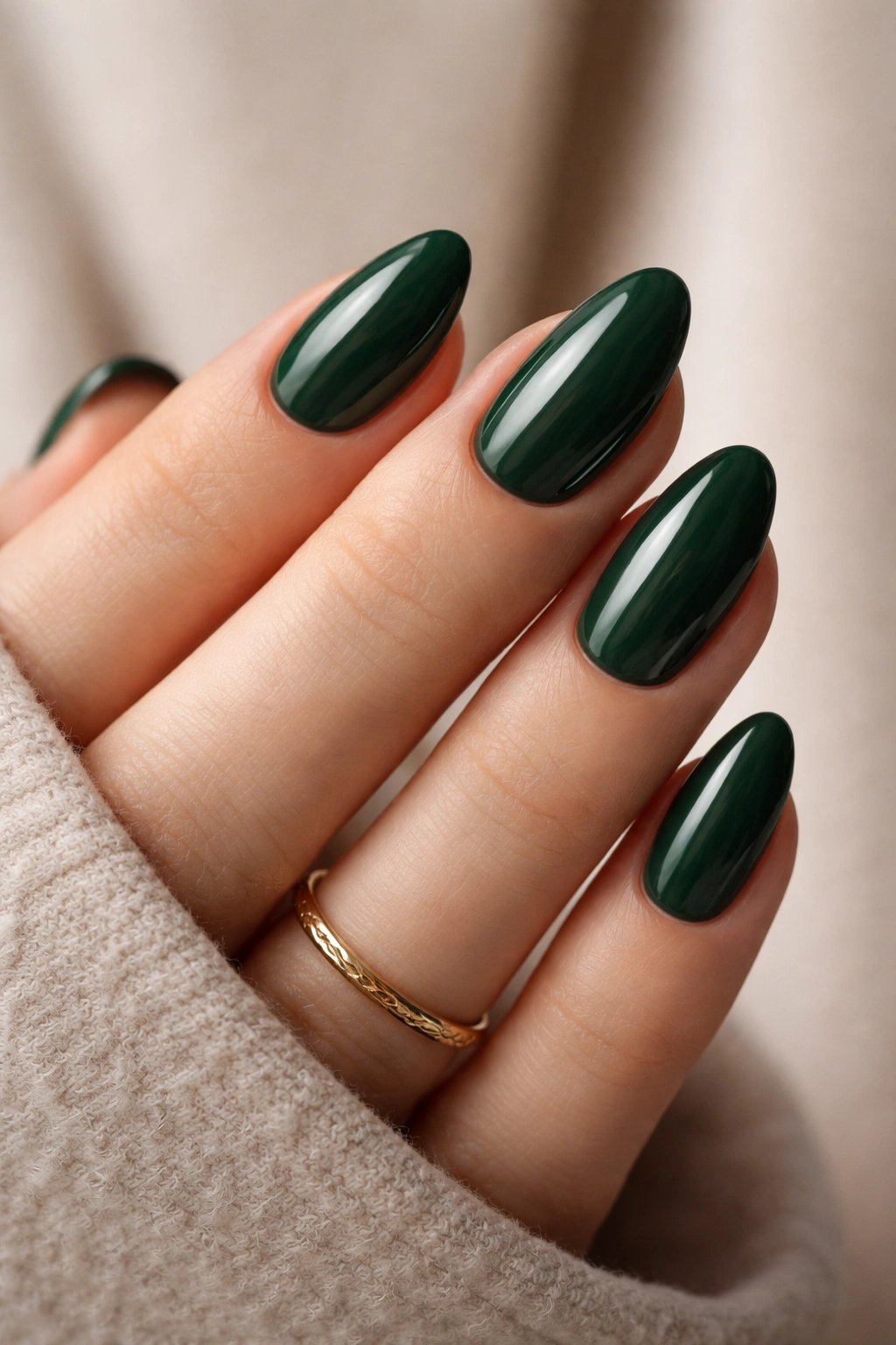 Close-up of deep forest green almond nails on a hand