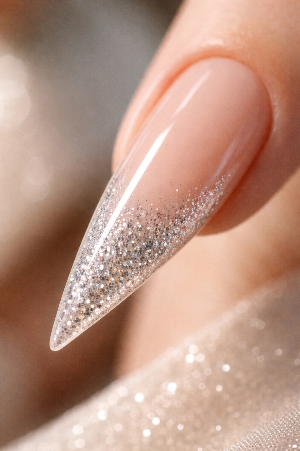 Stiletto nail nude with glitter gradient tip close-up