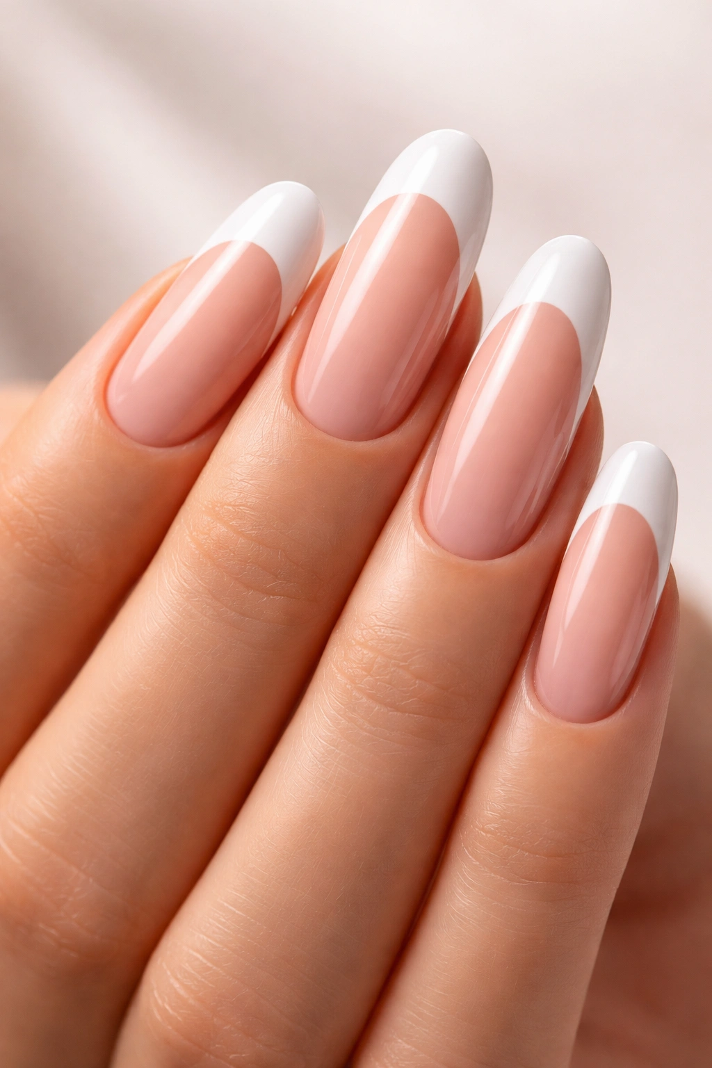 Close-up of extra-long round nails with crisp white tips on nude base