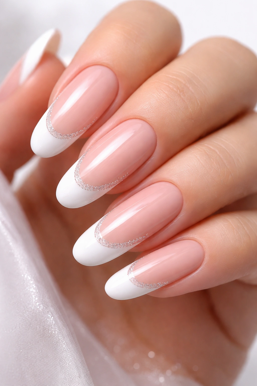 Close-up of long oval nails with nude base and modern French tip