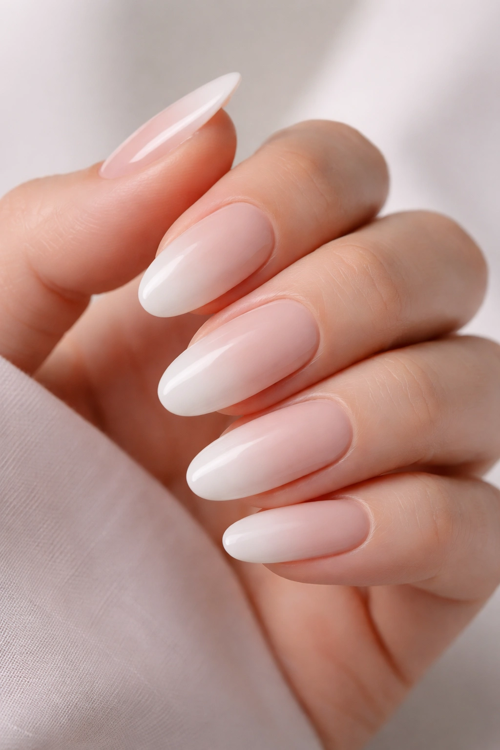 Close-up French ombre nails showing nude to white gradient