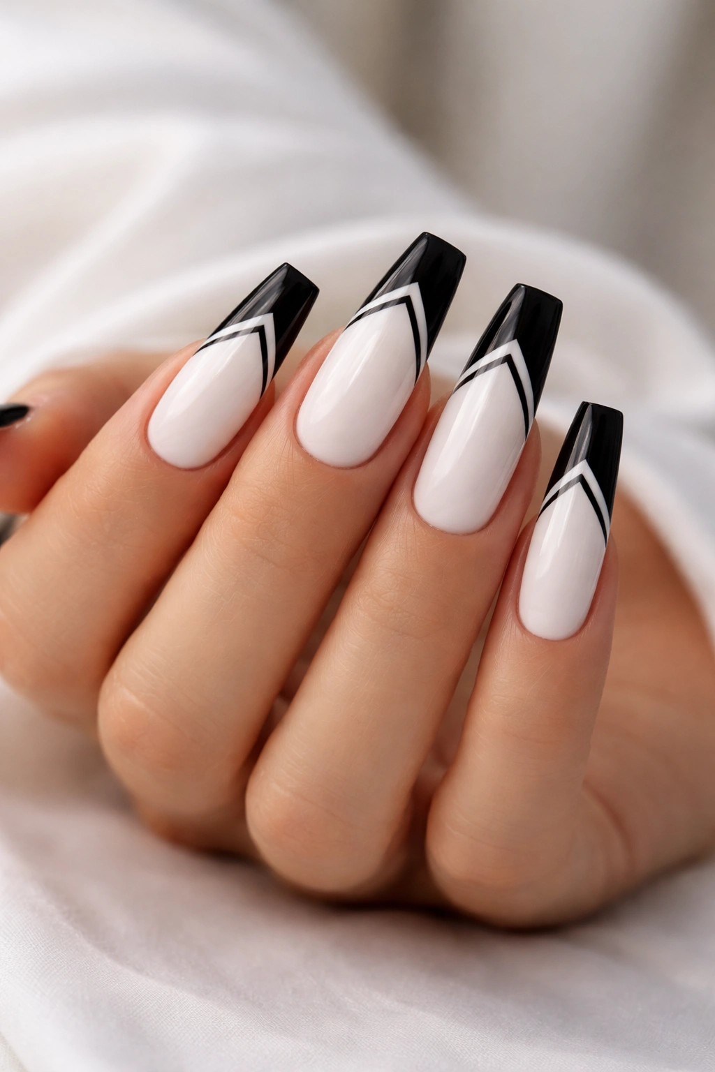 Coffin nails with white base, black tips, and black chevron across the white area
