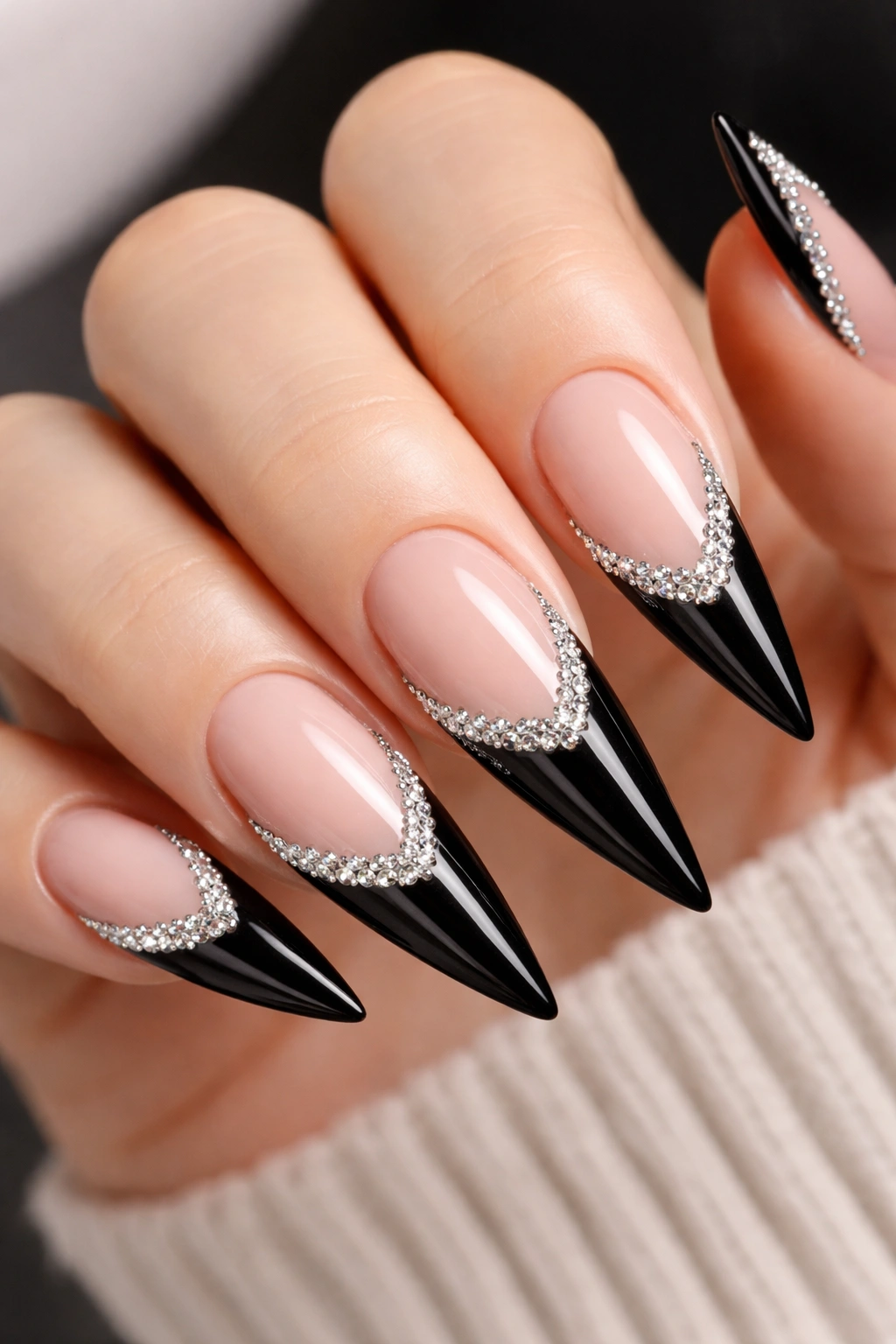 Black stiletto nails with rhinestone edge at the French tip