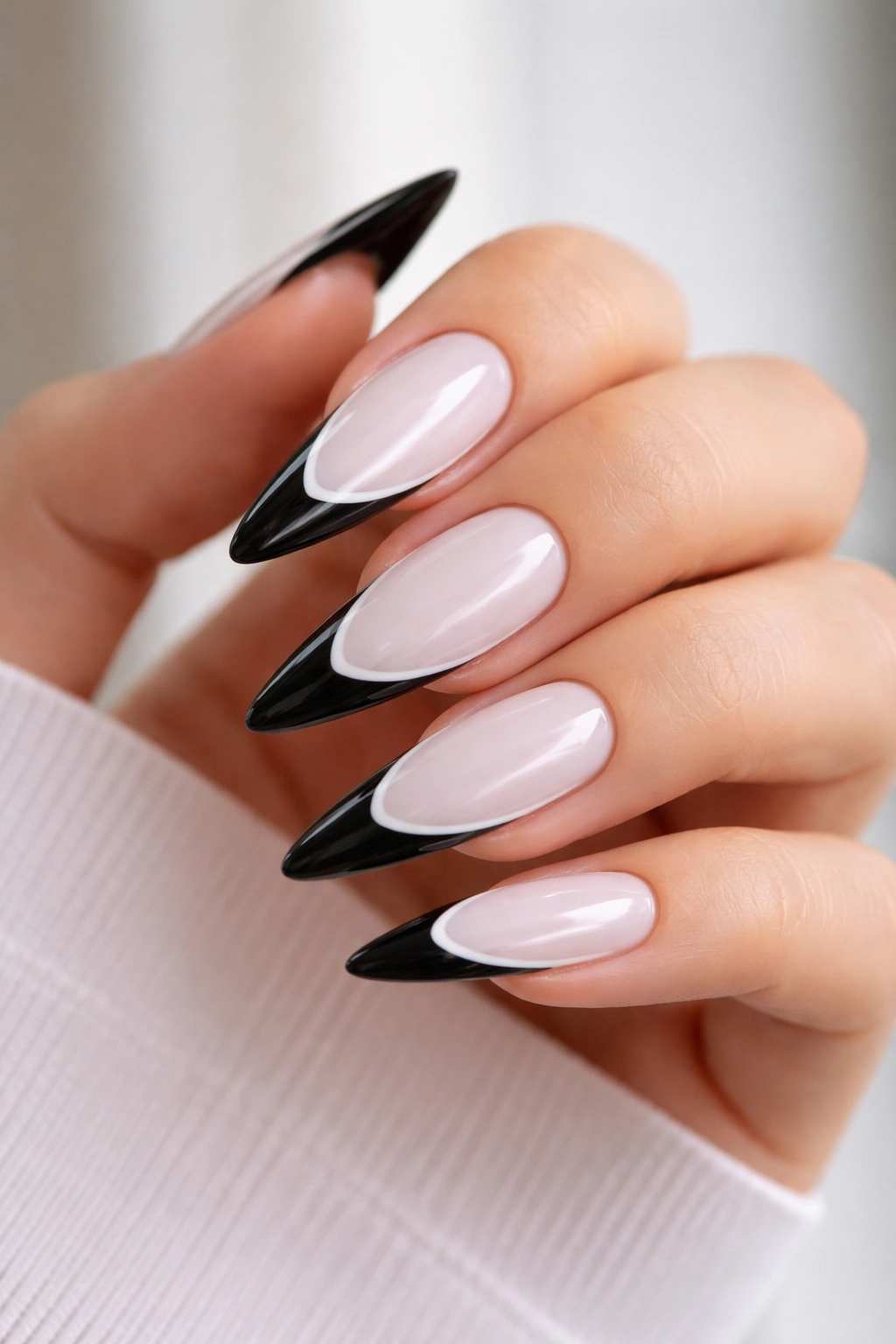 Stiletto nails with black French tips on white base