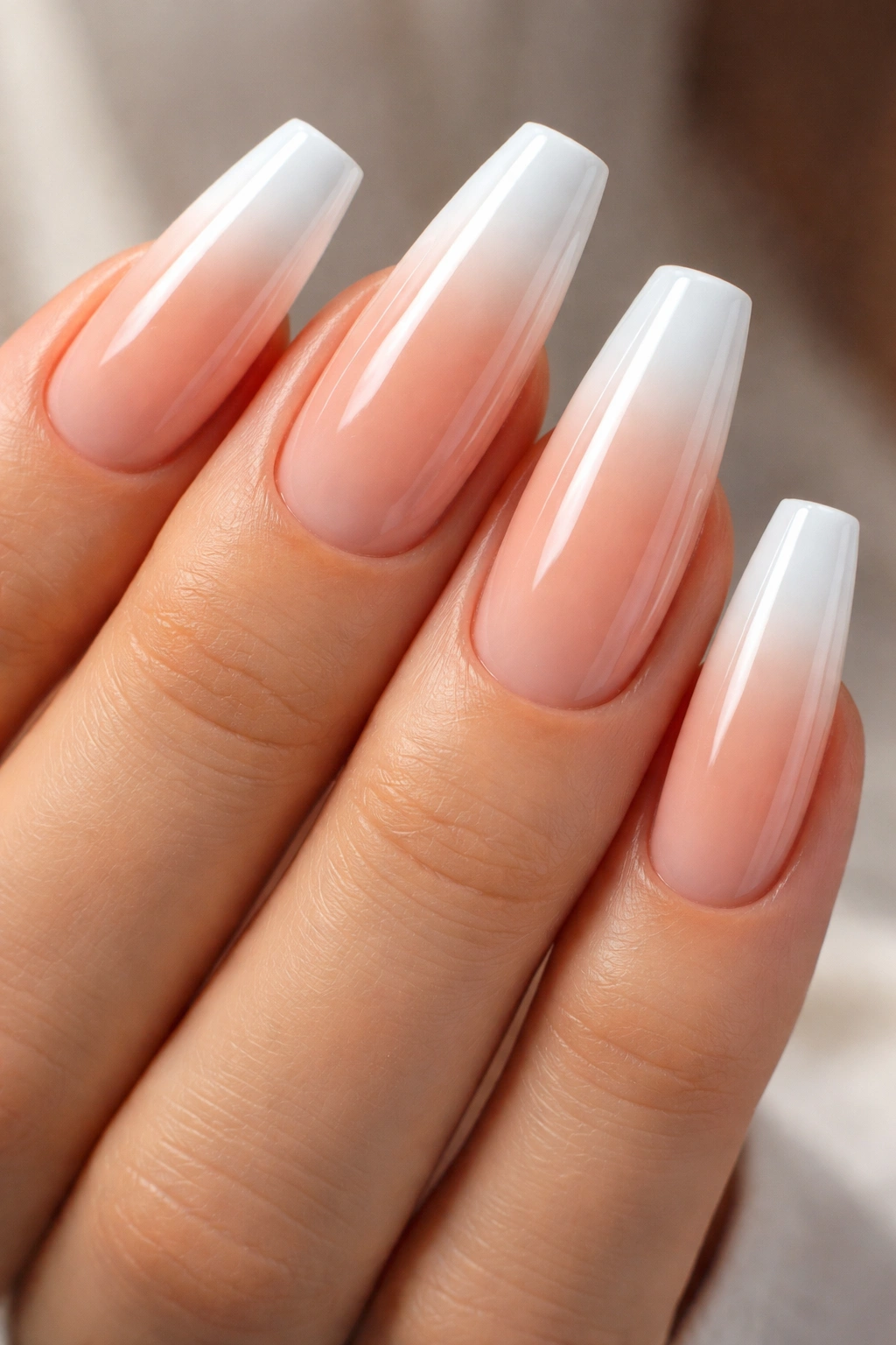 Close-up of coffin nails with gradient nude-to-white French tips