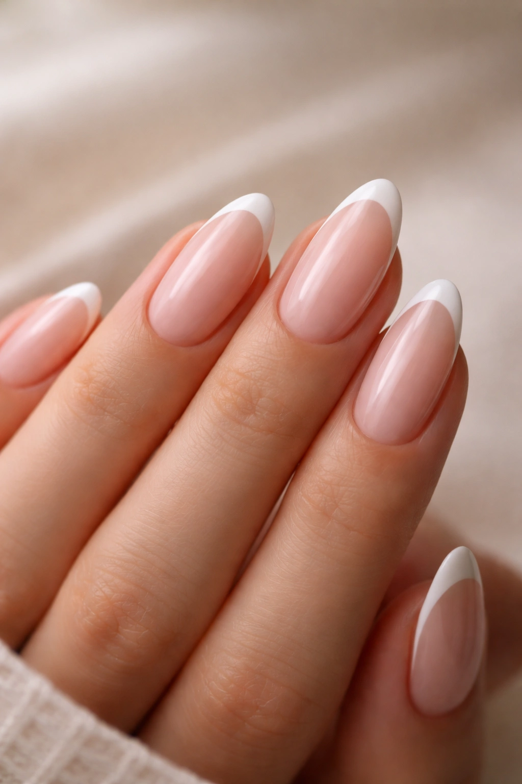 Close-up of tapered oval nails with slim white smile line on nude base