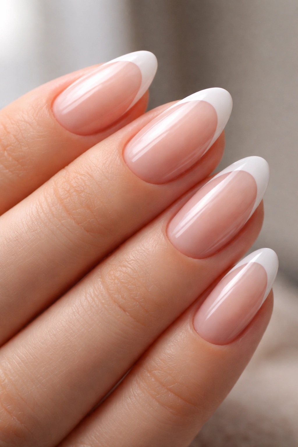Close-up of crisp French tips with glossy top coat on short almond nails