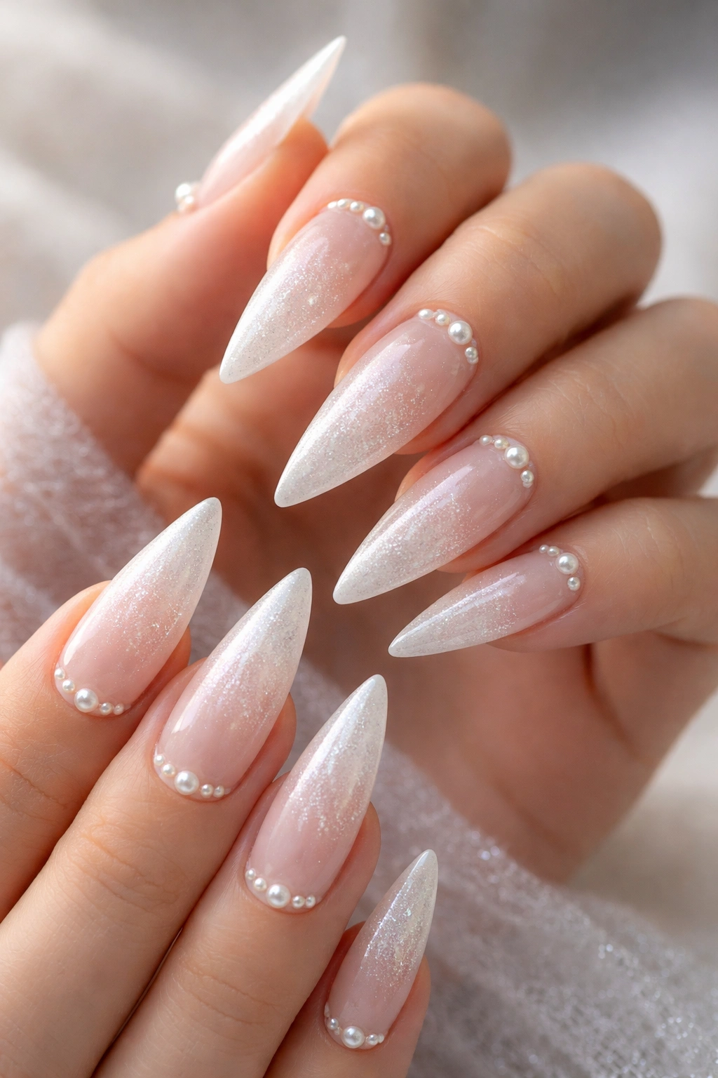 Frosted ombre nails with pearl accents on stiletto shape