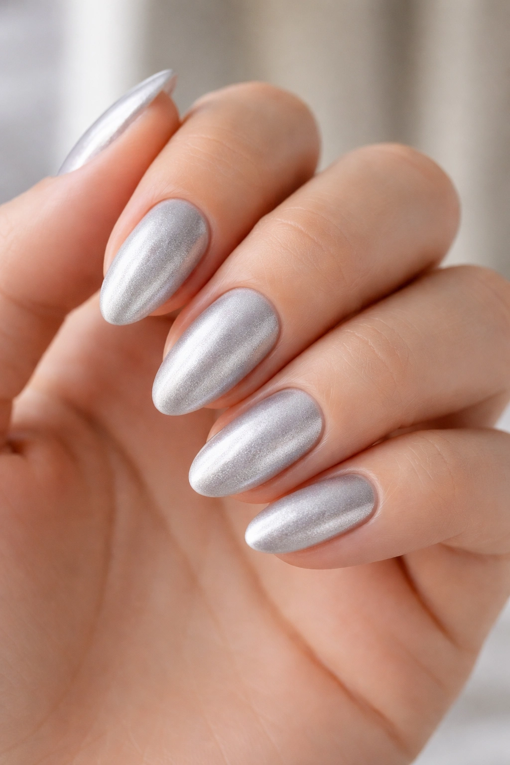 Close-up of short almond nails with frosted silver satin finish