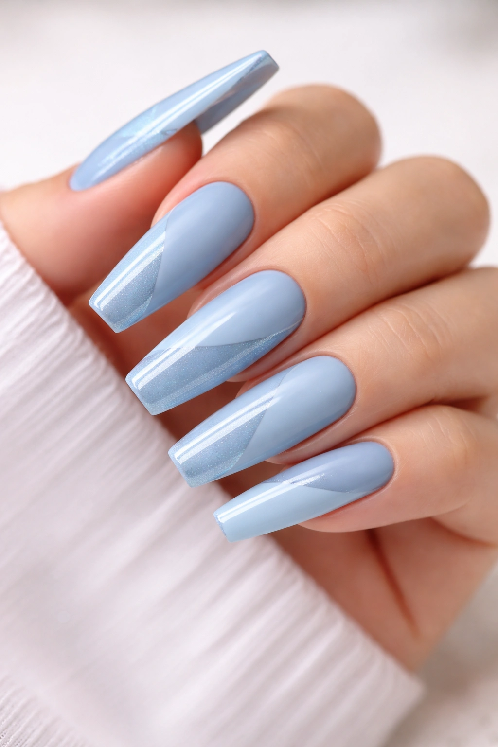 Close-up of frosty blue coffin nails with matte and gloss finishes.