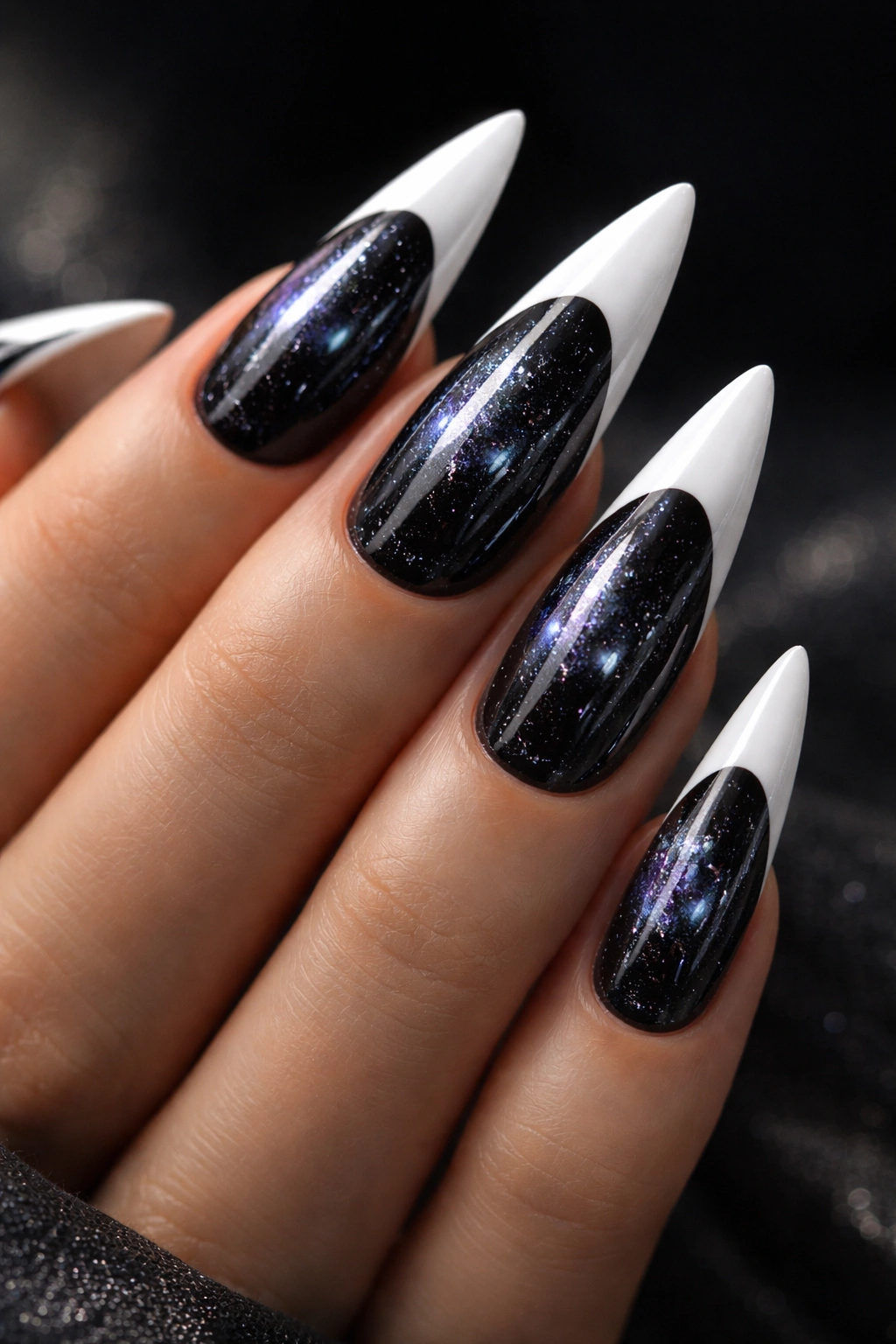Close-up of galaxy chrome nails with dark base, star-like specks, and white tips