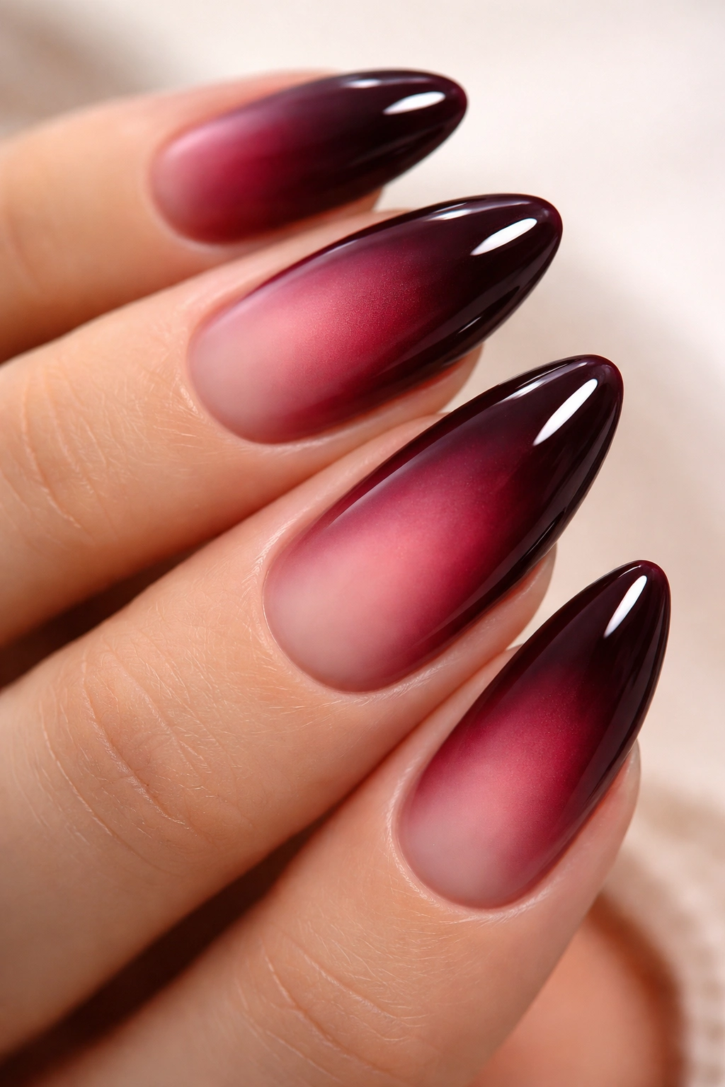 Close-up of garnet aura nails with dark edges and lighter center