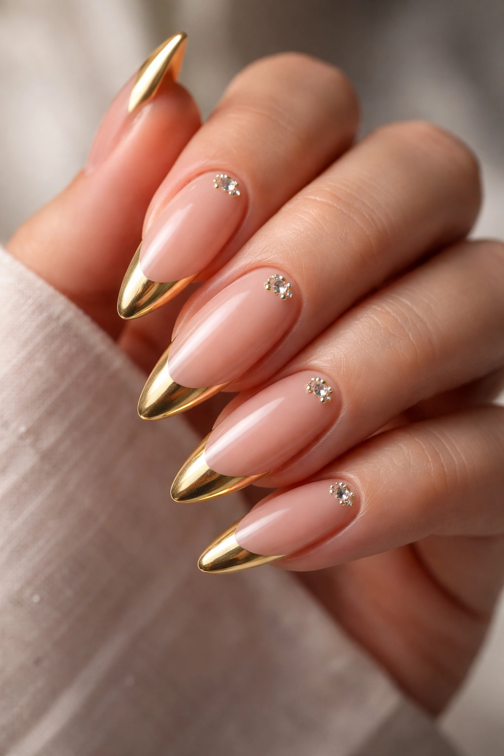 Almond nails with sculpted gold tips and gem accents