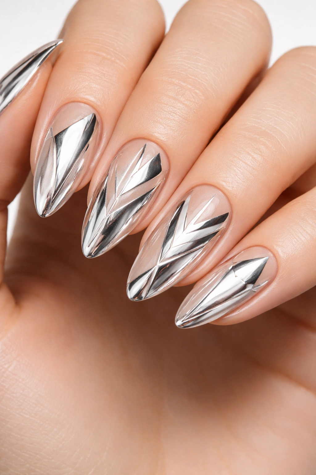 Close-up of geometric silver chrome nail art on nude base